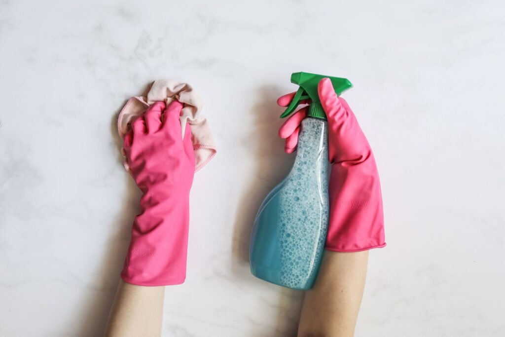 Profissional de limpeza usando luvas e produtos químicos de limpeza