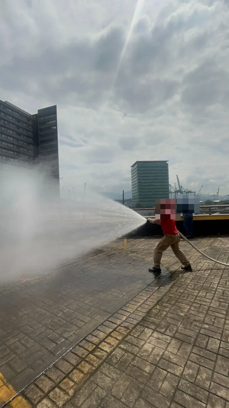 Treinamento prático de brigada de incêndio com mangueira